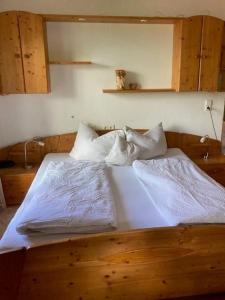 a bedroom with a bed with white sheets and pillows at Blaserhof Hainzenberg in Hainzenberg