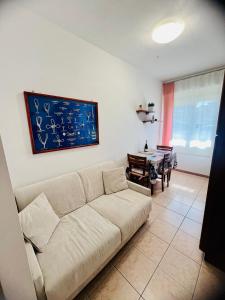 a living room with a couch and a table at Appartamento Villa Asio in Lignano Sabbiadoro