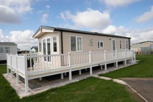 a small house with a porch and a white railing at Skegness Holidays in Skegness
