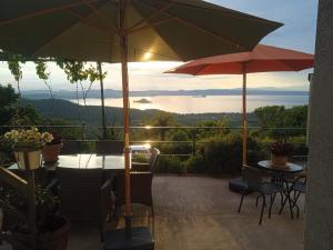 a patio with a table and two umbrellas at Virginia house in Montefiascone