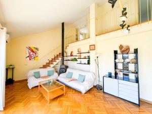 a living room with two white couches and a staircase at Duplex del Mar Castellon ComoTuCasa in Castellón de la Plana