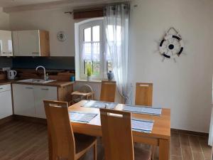 uma cozinha com uma mesa de madeira com cadeiras e uma janela em zwisch Boltenhagen und Pötenitz Ostseeurlaub bis 6 Pers"Alte Liebe" Haus A em Dassow