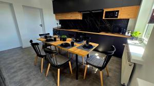 a kitchen with a wooden table and black chairs at Zebrzydowicka 37 in Rybnik +5 photos