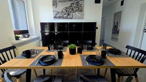 a dining room table with chairs and a wooden table with plates and glasses at Zebrzydowicka 37 in Rybnik