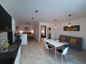 a kitchen and living room with a table and a couch at Ancsi Apartmanház in Balatonlelle