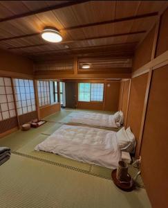 中津川市にあるGUESTHOUSE YANAGIYAの広い客室で、ベッド2台が備わります。