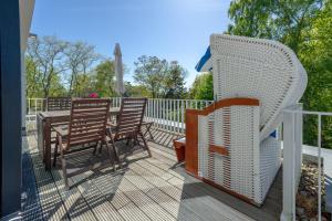 una terrazza con tavolo, sedie e recinzione di Haus Wetterhexe - FeWo 02 a Ostseebad Sellin