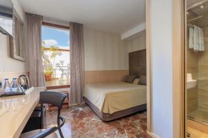 Habitación de hotel con cama y ventana en Hotel Gótico, en Barcelona