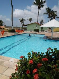 una piscina con agua azul y palmeras en Pargos Club de Salinas en Salinópolis