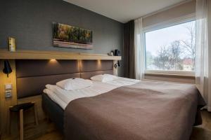 a bedroom with a large bed and a window at Hotelli Toivola in Kemi