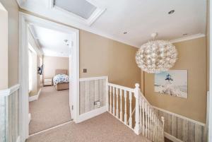 Habitación con cuna y lámpara de araña. en Georgian Town House, en Ilfracombe