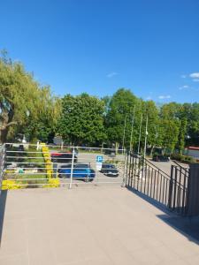 a gate to a parking lot with cars in a parking lot at MORSKI SEN-Przytulne studio z antresolą w centrum Mielna in Mielno
