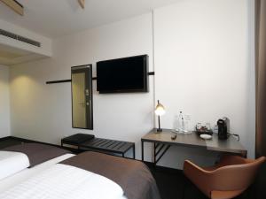 a hotel room with a bed and a desk and a tv at B&B Hotel Berlin City-Ost in Berlin