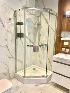 y baño con ducha y puerta de cristal. en Miracle Place en Ivano-Frankivsk