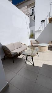 a patio with a couch and tables on a building at Ether Hydra-Aesthetic Residence in Hydra