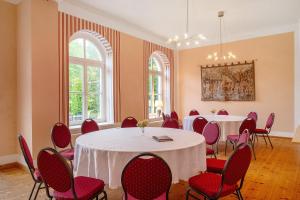 a room with two tables and red chairs in it at Herrenhaus Marienhof in Krakow am See