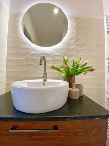 W łazience znajduje się biała umywalka i lustro. w obiekcie Stylish Studio near Dejvická metro station w Pradze