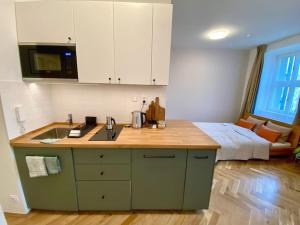 a kitchen with a counter with a sink and a bed at Stylish Studio near Dejvická metro station in Prague