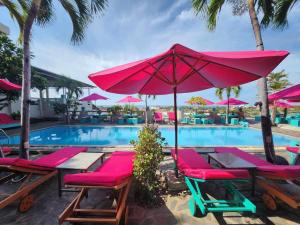 una piscina con sombrillas y sillas rosas junto a una piscina en Mui Ne Hills Bliss Hotel, en Mui Ne