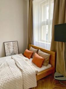 sypialnia z łóżkiem z poduszkami i oknem w obiekcie Stylish Studio near Dejvická metro station w Pradze