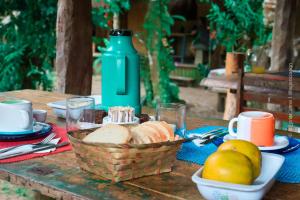 uma mesa de piquenique com pão e uma cesta de pão em Pousada Roy Bonete em Ilhabela