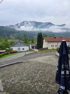 an umbrella sitting on the side of a road with a mountain at JÄGERWINKL 2 in Rettenberg