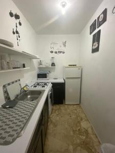 a kitchen with a sink and a stove and a refrigerator at Aqua Studio 6 in Negril