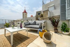patio con sofá y mesa en el balcón en Siwar Guesthouse, en Acre