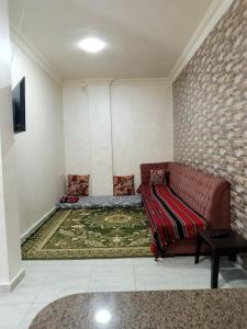 - un salon avec un canapé en cuir brun et un tapis dans l'établissement Jerash air apartment, à Jerash