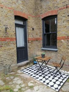 une table et des chaises devant un bâtiment en briques dans l'établissement 2 Bed Apartment in Sydenham, London, à Forest Hill