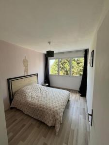 una camera bianca con un letto e una finestra di T3 de charme proche du centre a Douai
