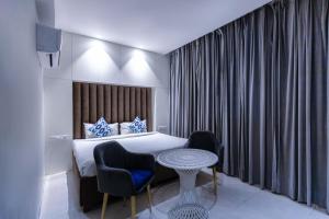 a hotel room with a bed and two chairs and a table at Hotel Downtown 17 in Chandīgarh