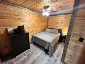 a bedroom with a bed and a wooden wall at Sage Hill Cabin in Londonderry