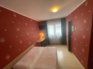 um quarto com uma cama num quarto com paredes vermelhas em Hafner Hotel- Apartment em Stuttgart