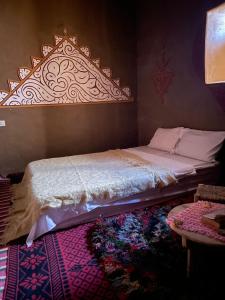 1 dormitorio con 1 cama con cabecero decorativo en Dar Laassri Tours, en Mhamid