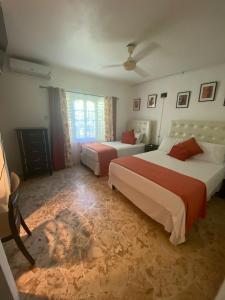 a hotel room with two beds and a window at Aqua Studio 6 in Negril