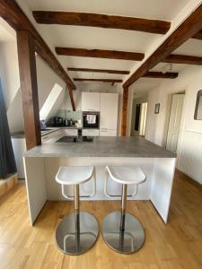a kitchen with a large counter and two stools at LudwigsHome: Zentralste Lage, SmartTV, Terrasse in Ludwigsburg
