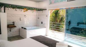a large bathroom with a tub and a large window at Eco Hotel Montenegro in Medellín