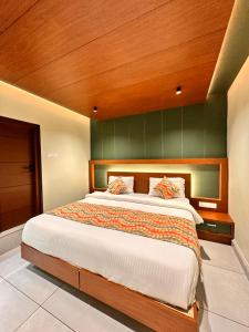 a bedroom with a large bed with a wooden headboard at Hotel City Palace in Ooty