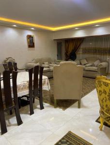 ein Wohnzimmer mit einem Tisch, Stühlen und einem Sofa in der Unterkunft شقة فندقية مميزة بالمنصورة in Ṭalkha