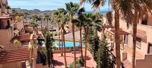 an aerial view of a hotel with palm trees and a swimming pool at Tranquil apartment close to pool in Águilas