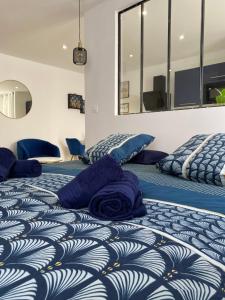 2 łóżka z niebieskimi poduszkami w pokoju w obiekcie Cosy Appart’ & spa - Appartement privatif - baignoire balnéothérapie 