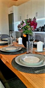 una mesa con platos y vasos y un jarrón de flores en Philoxenia guest house, en Himare