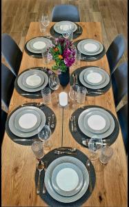 希馬拉的住宿－Philoxenia guest house，一张木桌,上面有盘子和玻璃杯,上面有鲜花