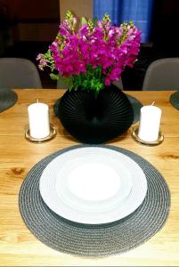 una mesa con un plato y flores y velas en Philoxenia guest house, en Himare