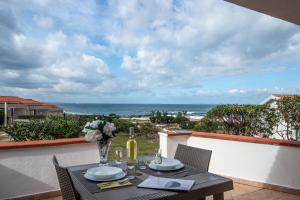 een eettafel met uitzicht op de oceaan bij Residence Cala del Mar - Happy Rentals in Marina di Sorso