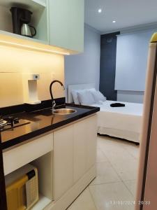 a kitchen with a sink and a bed in a room at Quitinete ACONCHEGANTE in Rio de Janeiro