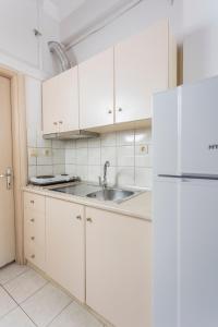 佩科霍里的住宿－Ice Hot Rooms Pefkochori，白色的厨房配有水槽和冰箱