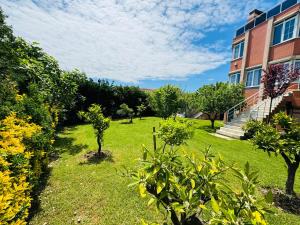 un jardín con árboles y un edificio con un edificio en Istanbul Airport Treekos Suite Hotel en Karaburun