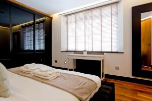 a bedroom with a bed with two towels on it at Luxury 2 Bed Knightsbridge Flat in London